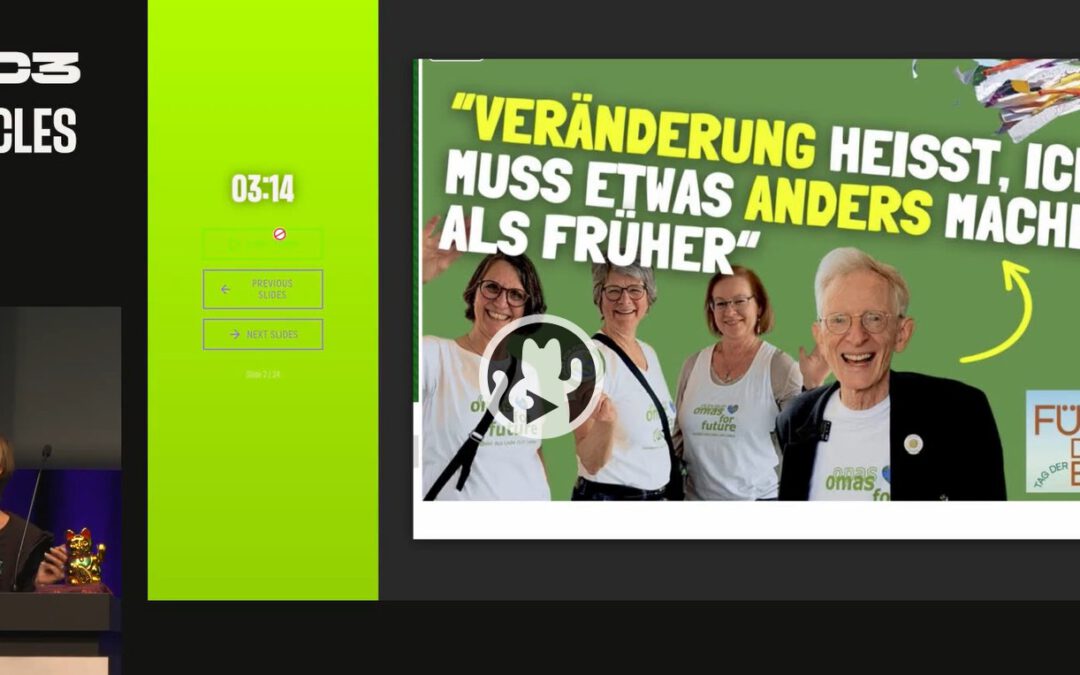 Eine Frau spricht an einem Podium auf der Bühne. Neben ihr zeigt eine Präsentationsfolie vier lächelnde ältere Erwachsene mit einem deutschen Text über den Wandel, einem herzförmigen Erdlogo und der Aufschrift "FÜR die ERDE". Der Bildschirmhintergrund ist hellgrün.