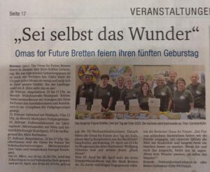 5 Jahre O4F Nov 2026 Bretten©O4F - Omas for Future Ein Zeitungsartikel mit der Überschrift Sei selbst das Wunder. Unten ist ein Foto einer Gruppe von Menschen in passenden T-Shirts zu sehen, die zusammenstehen und lächeln, um den fünften Jahrestag von Omas for Future Bretten zu feiern.