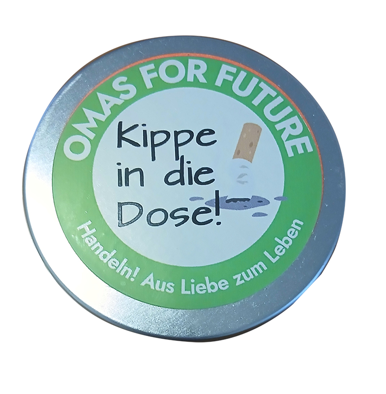 Dose 1000073611 - Omas for Future Eine runde Dose mit einem Etikett, auf dem „OMAS FOR FUTURE – Kippe in die Dose! Handeln! Aus Liebe zum Leben“ steht und das eine Zigarettenkippe zeigt, die in einem Behälter entsorgt wird.